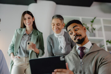 Team Collaborating Enthusiastically Around Tablet in Workplace
