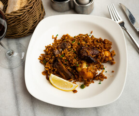 Sea paella is traditional Spanish dish, prepared using shrimp, mussels, shellfish and complemented with chicken meat. Lemon slices, spices, and light alcohol are served with food