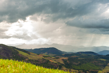 Obraz premium Rain falling over hills and mountains in the Brazilian countryside. Landscape with cloudy and rainy sky