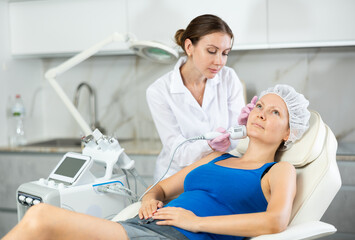 Cosmetologist makes cryo therapy lifting with skin rejuvenation and smoothing for woman use...