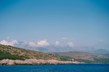 Fototapeta premium Deserted mountainous sea coast in a light summer haze