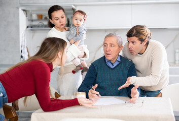 People of different generations argue with each other and show an elderly father how to fill out documents correctly