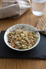 Quinoa salad with vegetables in a bowl with fork rustic style 
