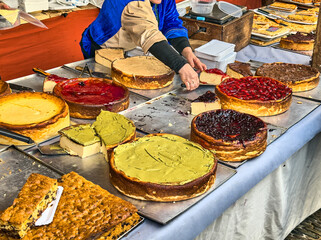 Artisan cheesecakes with various toppings at a market stand