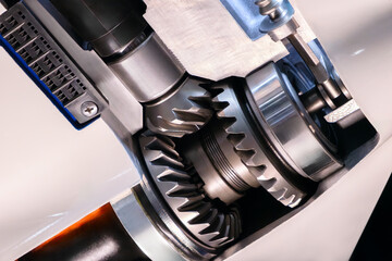 Close-up of a gear in black and silver color scheme. The gears are in the gearbox housing, the housing is open. Stripped down gearbox of a boat motor.