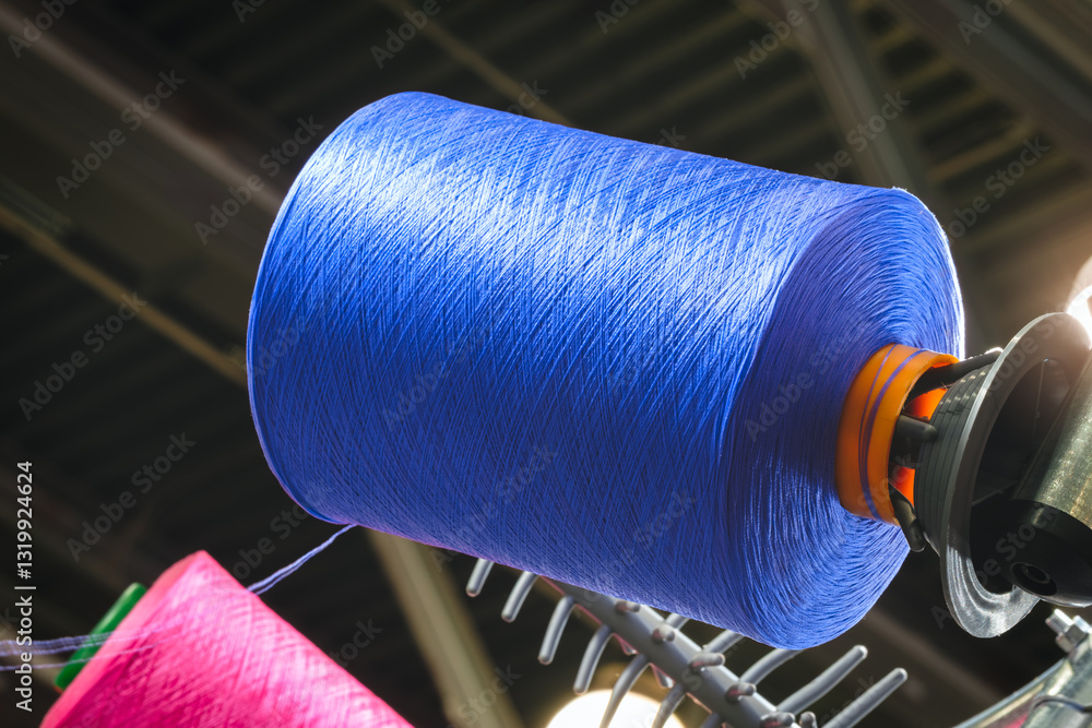 Aufkleber a blue spool of thread is hanging from a rack. the spool is made of a synthetic material and is abou
