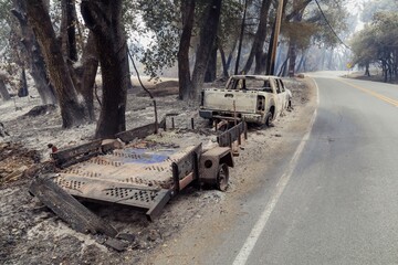Burnt truck and trailer sit on the roadside after a wildfire swept through the area in Santa Cruz,...