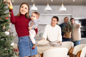 Woman decorating Christmas tree, family preparing for Christmas