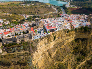 Aerial view of Arcos de la Frontera city with medieval castle on edge of cliff