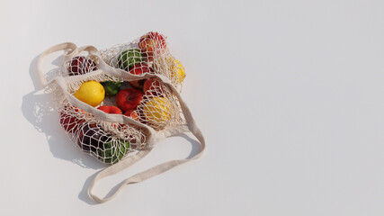 Close-up of various fruits in a woven eco-bag, showcasing vibrant colors and natural textures