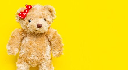 Teddy bear on yellow backgrond.