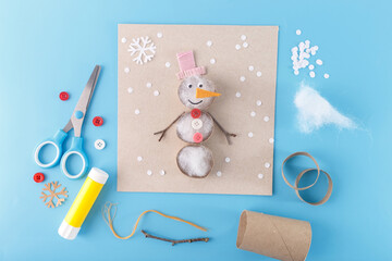 Fun craft project with a snowman made from various materials like cotton stuffing, buttons, and twigs. Suitable for holiday decorations, craft supplies, or children activity-based businesses.