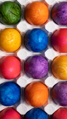 Multicolored Easter eggs lie in a white tray close-up