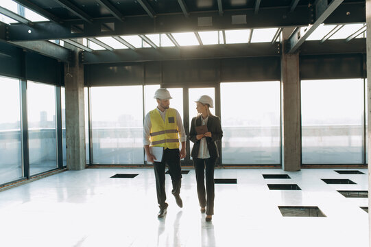 Construction Professionals Discussing Project Progress in Modern Office Space. architect or engineer and designer communicating at construction site