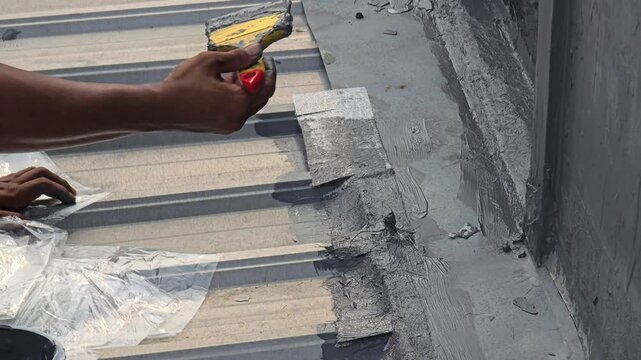 The repairman repaired the leaking roof of the house, patching the tiles with fiber and coating them with leak-proof paint.