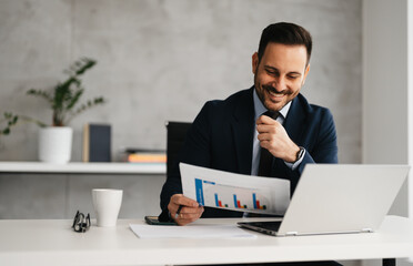 Handsome businessman on desk doing business analysis