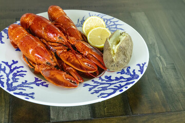 Whole lobsters from Maine on a nautical dish with a baked potato