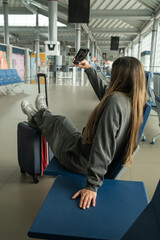 young latina girl taking a selfie at the airport, copy space