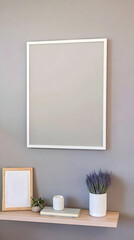 Modern minimalist home interior with a large white frame on a gray wall, complemented by a shelf with a small wooden frame, a potted plant, and dried lavender.