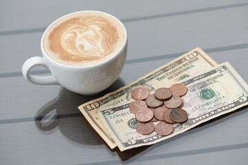 Tip and coffee on wooden table in outdoor cafe