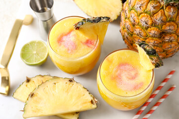 Tasty pineapple cocktail in glasses served on white table, above view
