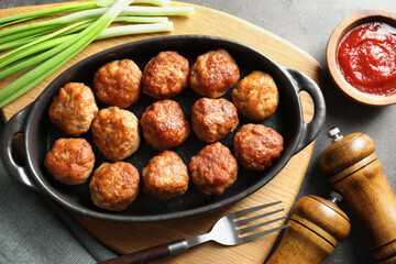 Tasty meatballs served on grey table, flat lay