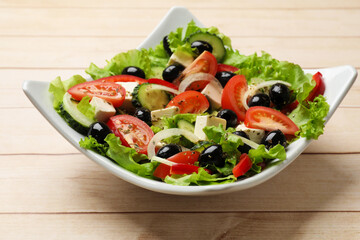 Delicious fresh Greek salad on white wooden table, closeup