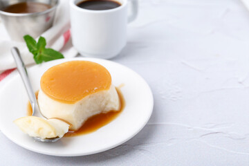 Tasty pudding with caramel sauce served on white textured table, closeup. Space for text