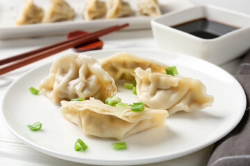 Delicious gyoza dumplings with chives served on white table, closeup
