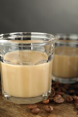 Coffee cream liqueur in glasses and beans on table, closeup