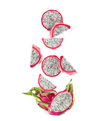 Pieces of tasty pitaya fruit falling on white background