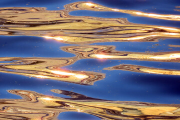 abstract nature background, water surface with waves at sunset