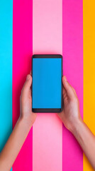 Hands Holding Smartphone with Blank Blue Screen on Colorful Background