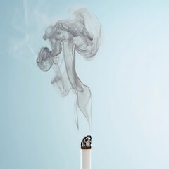 Fototapeta premium A burning cigarette releases grey smoke against a blue backdrop