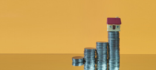 Investment growth stacked coins and house model representation in business environment