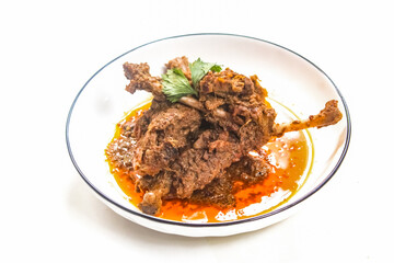duck meat dish on a plate, cooked in a traditional way using spices and coconut. Isolated on a white background.