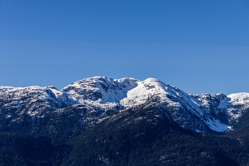 Snow-Covered Chief Mountain Peak in Squamish, BC Against a Blue Sky