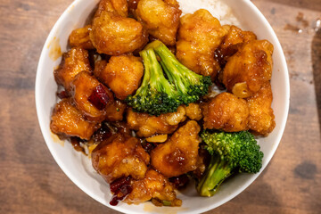 Bowl of saucy chicken and broccoli on rice. Sweet and savory dish with tender chicken, crisp broccoli, and sticky sauce is the perfect meal.
