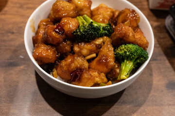 A delectable bowl features perfectly glazed chicken bites complemented by fresh broccoli florets, creating a flavorful and visually appealing dish.
