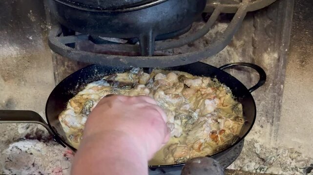 A creamy veal sweetbreads and morel mushroom dish gently cooking in a pan, releasing rich aromas