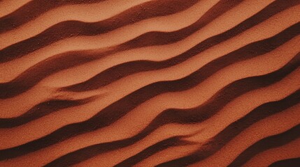 A close-up view of wavy patterns in rich, reddish-brown sand, showcasing natural textures and lines formed by wind erosion.