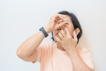 Elderly Woman use ophthalmic solutions or Eye Drops after eye surgery. Eye disease, Cataract, ...
