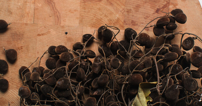 Overhead view of velvet tamarind on wood countertop, top view of velvet tamarind bunch on wood background