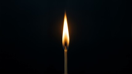 A lit candle against dark background.