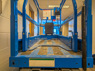 open gate to a scissor lift lowered inside a building construction project. 