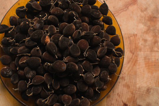 Overhead view of velvet tamarind on wood countertop, top view of velvet tamarind bunch on wood background