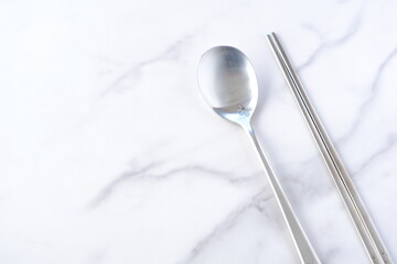 韓国スタイルの、ステンレス製の食器。スプーンの「スッカラ」と、お箸の「チョッカラ」で食事をするイメージ
