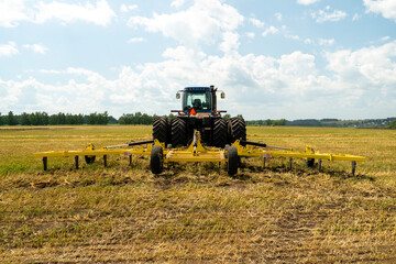 tractor working in a field on a bright sunny day. The concept of work in a fields and agriculture...
