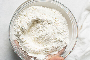 overhead view of All purpose flour in a bowl, top view of baking flour in a glass bowl