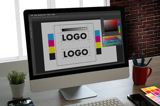 graphic designer using a tablet and computer to create a brand logo with a colour palette in Illustrator for a company.